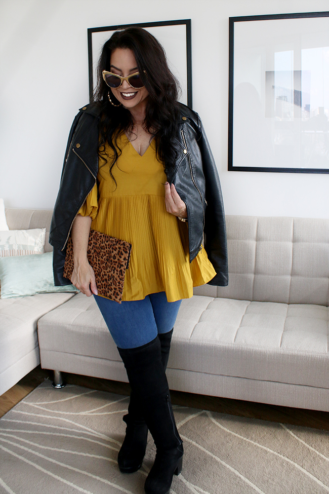 Mustard peplum top with skinny jeans and black leather jacket with over the knee boots and leopard print clutch