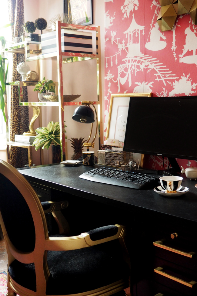 boho glam home office with black desk and pink wallpaper