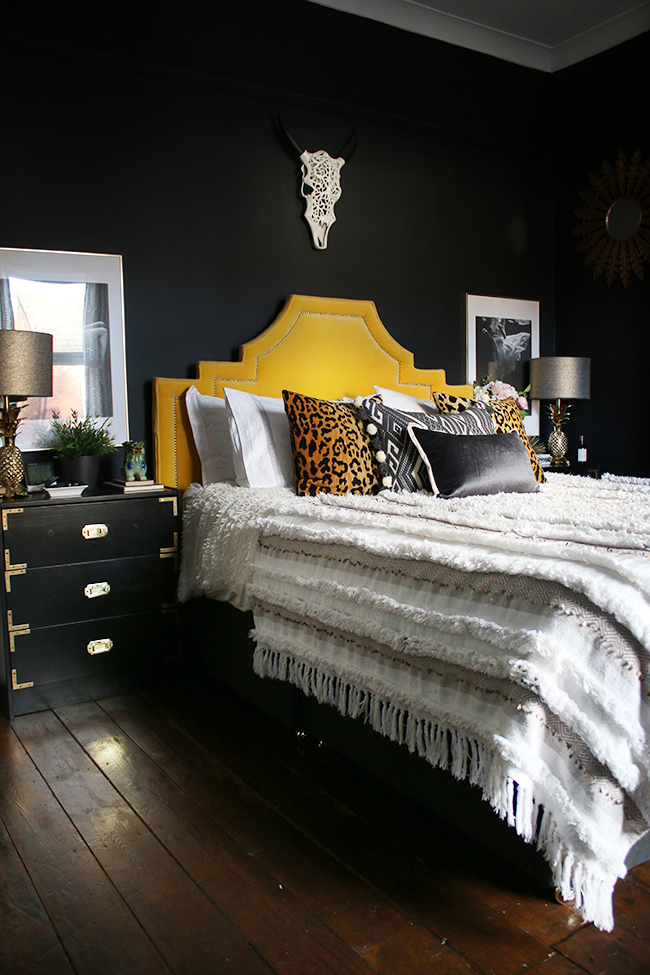 black bedroom with gold headboard boho glam